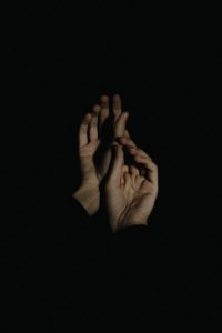 Artistic portrayal of hands in a minimalist dark setting, embodying elegance and expression.